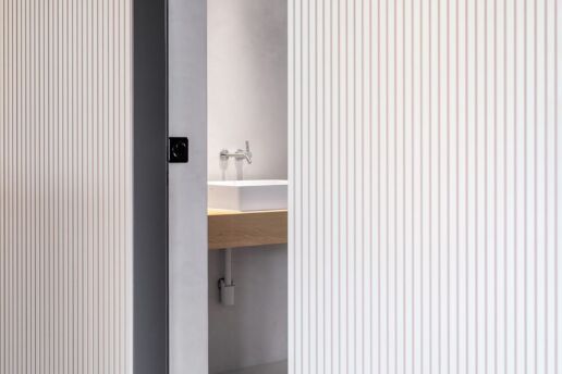 Wandverkleidung aus Akustikplatten mit feinen Lamellen in Linoleum